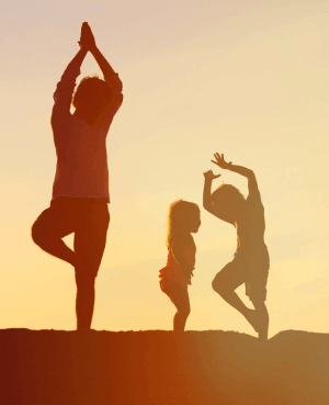 Shadow silhouettes of a mom and two children doing yoga poses