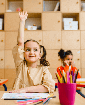 Young girl raising her hand in class