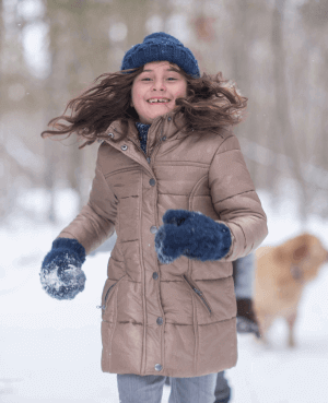 Young girl running outside during the winter