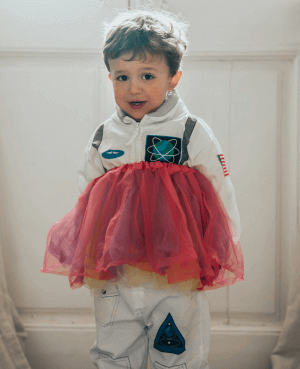 Young boy wearing an astronaut costume and skirt