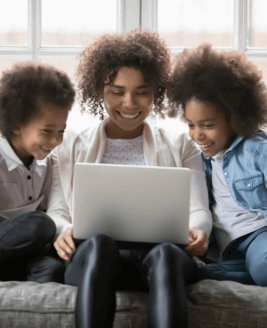 A mother and her 2 kids looking at a laptop screen