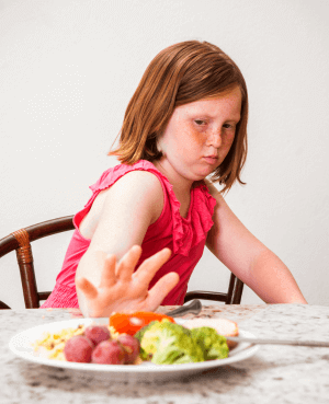 A child pushing away a plate of food