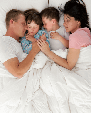Two parents & two children all sleeping in the same bed