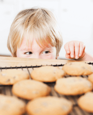 Child trying to sneak a cookie off the counter