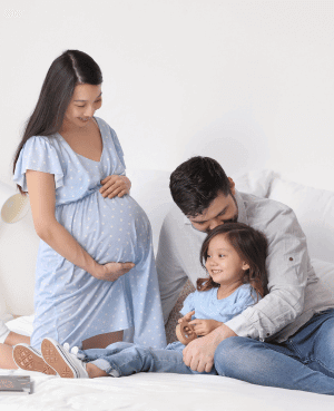 Mother holding pregnant belly while talking to her child