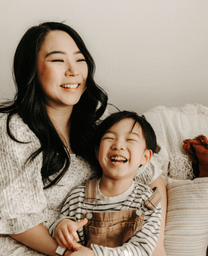 Smiling mother and child sitting together, depicting a positive parent-child relationship and the joy of raising capable kids. Ideal for discussions on essential skills for children to thrive in today's world.