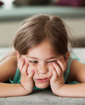 Little girl looking bored with chin resting on hands