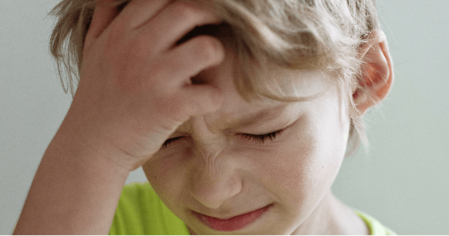 Child upset, holding head in hands