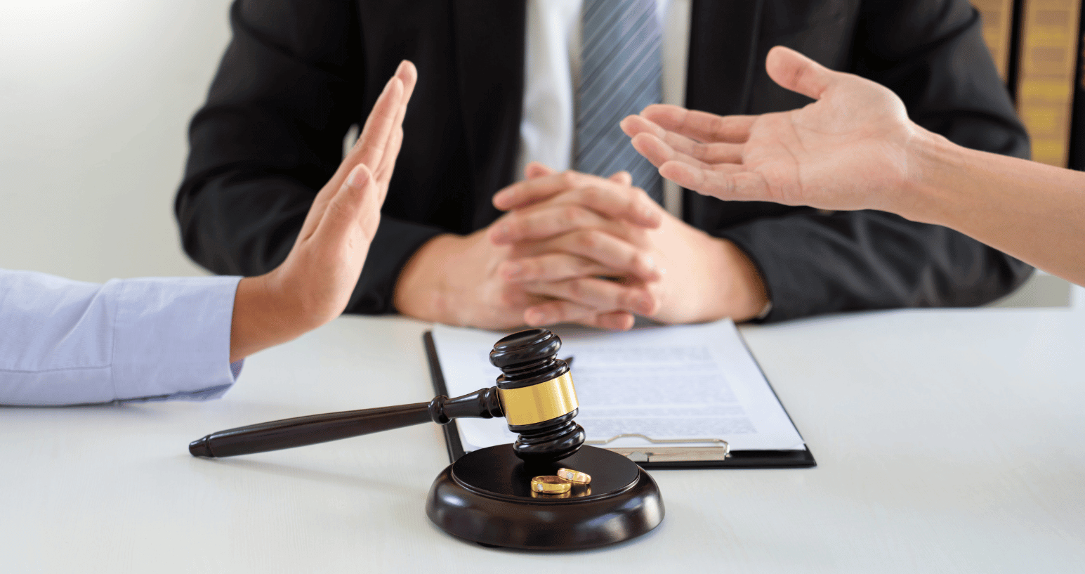 Divorcing couple discussing custody with attorney during mediation.