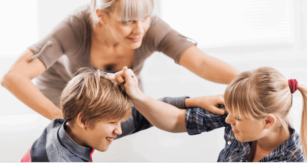 Parent intervening while two children pull each other’s hair.