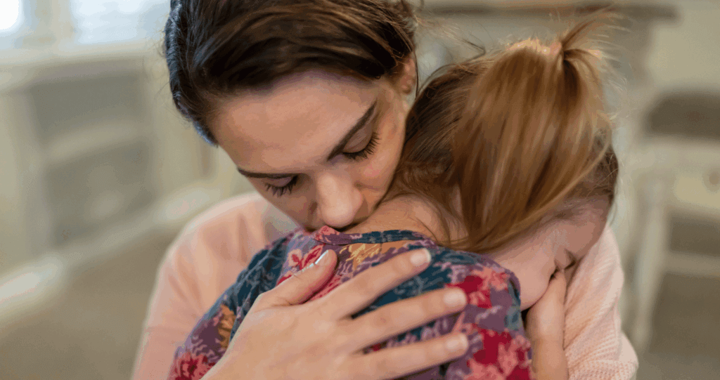 Mother hugging upset child to provide comfort and connection.