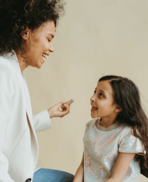 Parent and daughter smiling and talking to build confidence and connection.