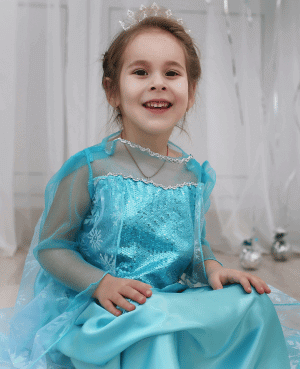 Smiling toddler in a blue princess dress, representing a child who insists on the same outfit every day.
