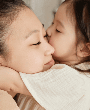 Parent and young child sharing a close embrace, representing secure attachment and emotional attunement.