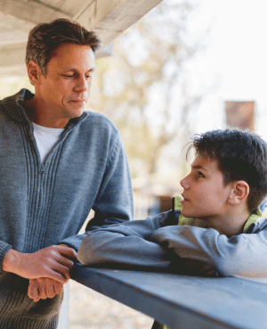 Father talking with his son outdoors, reflecting secure attachment and emotionally present fatherhood.