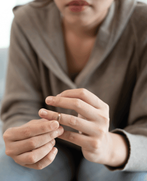 Person holding a wedding ring, representing separation, divorce grief, and emotional transition.