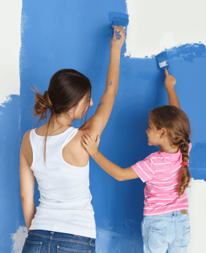 Parent and child painting a blue wall together, showing home design that supports child regulation.