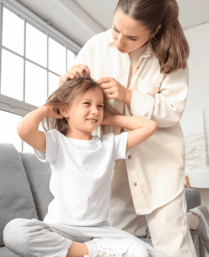 Parent checking a child’s hair for lice, showing gentle support and at-home lice care.