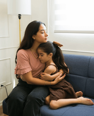 Caregiver holding an anxious child, reflecting connection, comfort, and emotion regulation.