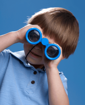 Child looking through binoculars, symbolizing curiosity, neurodivergence, and a strengths-based view of kids.