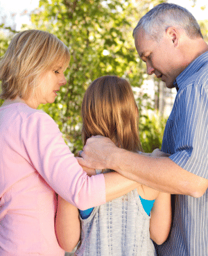 Parents standing with a child, symbolizing support, stability, and connection during divorce.