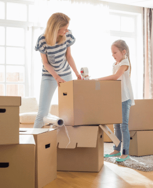 Parent and child packing moving boxes together, representing emotional preparation for a family move.