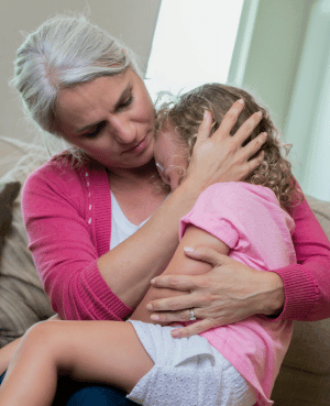 Adult holding an upset child, representing comfort, connection, and co-regulation.