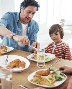 Father serving a child a balanced meal, illustrating the gut-brain connection and family nutrition.