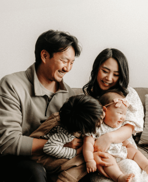 Parents laughing with their young children, representing connection, emotional validation, and healthy boundaries.