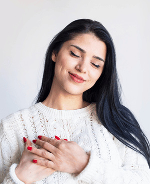 Woman holding her hands over her heart, representing self-worth, self-compassion, and secure attachment with yourself.