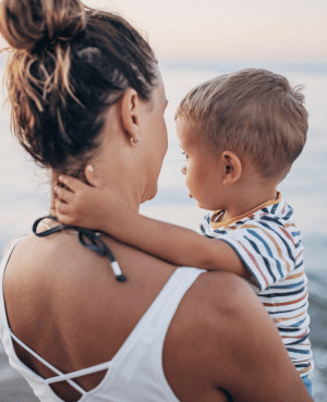 Mother holding a young child, representing secure attachment, connection, and breaking intergenerational patterns.