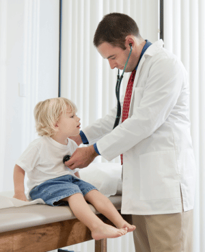Doctor examining a worried young child, illustrating fear, distress, and a child’s need for caregiver comfort.